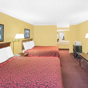 北小石城Travel Inn North Little Rock的酒店客房 - 带两张红色床罩
