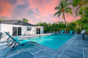 北迈阿密海滩Miami 4Bedroom Retreat heated Pool near to beach的一个带椅子的游泳池以及一座房子