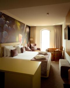 拉梅戈Douro Castelo Signature Hotel & Spa的酒店客房设有一张大床和一张沙发。