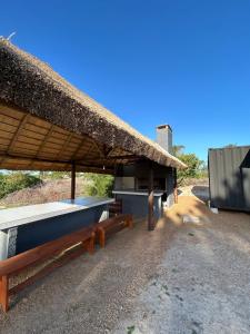 若雷吉贝里Casa Conteiner en campo con playa privada. max 6 personas的凉亭,带长椅和茅草屋顶