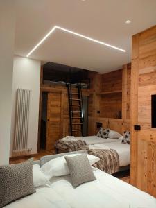 布勒伊-切尔维尼亚Fior di Roccia Apartments的木墙客房的两张床