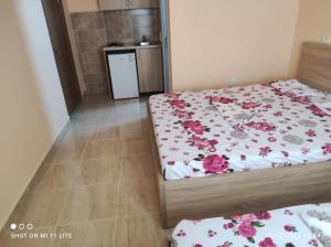 乌尔齐尼Grandino rooms&apart的一间卧室配有两张带鲜花的床单
