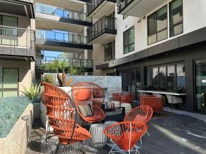 洛杉矶APARMENT IN SUNSET的一座庭院,里面设有橙色的椅子和桌子