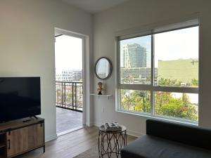 洛杉矶APARMENT IN SUNSET的客厅配有平面电视和大窗户。