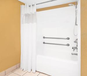 北小石城Travel Inn North Little Rock的配有白色窗帘的淋浴的浴室