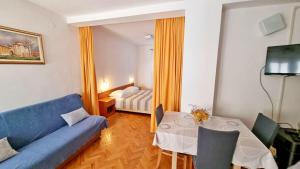 柳巴茨Apartments Poljubac的客厅配有蓝色的沙发和桌子