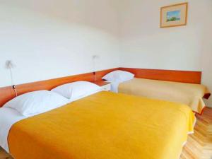 柳巴茨Apartments Poljubac的黄色毯子的客房内的两张床