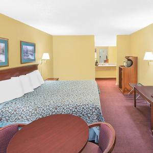 北小石城Travel Inn North Little Rock的酒店客房设有一张大床和一张桌子。