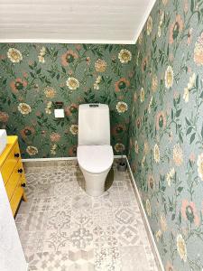 莫拉Lyxig oas med modern elegans的浴室设有卫生间和花卉壁纸。