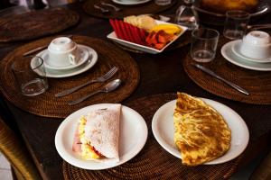 萨尔瓦多矮牵牛之家精品旅馆的餐桌上放有食物盘子的桌子
