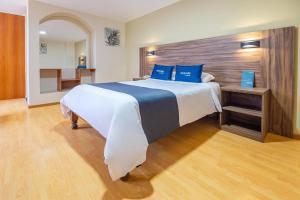 阿雷基帕Premier Tambo的大卧室配有一张带蓝色枕头的大床