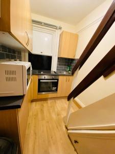 斯劳Briton Room的一间带木制橱柜的厨房和带微波炉的楼梯