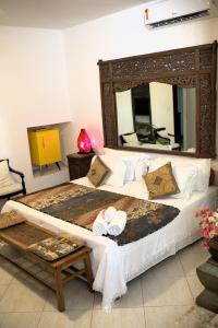 萨尔瓦多矮牵牛之家精品旅馆的一间卧室配有一张大床和大镜子