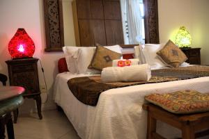 萨尔瓦多矮牵牛之家精品旅馆的一间卧室设有两张床和红灯