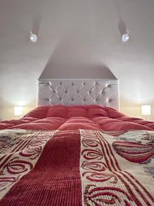 圣胡安Güemes Apart的一间卧室配有一张带红色毯子的大床