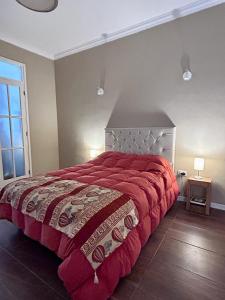 圣胡安Güemes Apart的一间卧室配有一张带红色毯子的大床