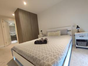 WoolwichLuxury Riverside Apt with easy access to Central London, O2, Excel centre and Parking的一间卧室,床上有鞋