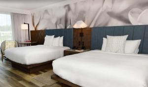利胡埃The Royal Sonesta Kauai Resort Lihue的酒店客房带两张床和一面墙