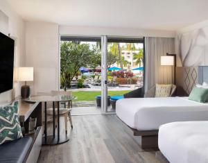 利胡埃The Royal Sonesta Kauai Resort Lihue的酒店客房配有床、沙发和电视。