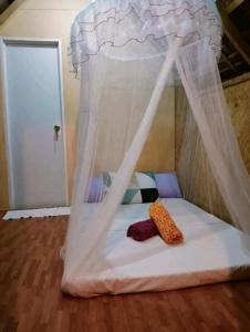 爱妮岛Balai Ko Beach & Cottages的一张小床,在房间里设有天蓬