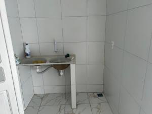 奥林达Casa união的一间带水槽和白色瓷砖墙壁的浴室