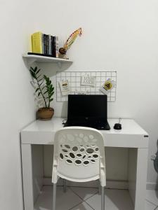 若昂佩索阿Quarto Encantado的一张带笔记本电脑和椅子的白色书桌