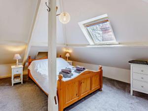 迪姆彻奇3 bed property in Aldington 54088的一间卧室设有一张木床和一个窗户。