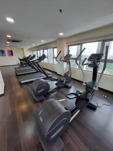 莎阿南Suria Homes的健身房设有一排跑步机和椭圆机