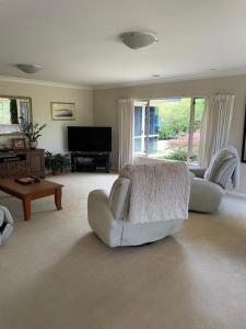 帕拉帕拉乌穆Spacious Home的客厅配有两把白色椅子和电视