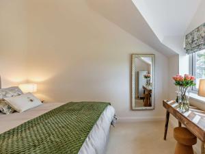 1 Bed in Melton Mowbray 93068的一间卧室配有一张床和一张带镜子的桌子