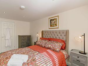 Wilsden1 Bed in Bingley 91492的一间卧室配有一张带红色毯子的大床