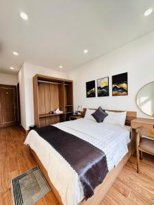 富国DTJ Hometel GRAND WORLD的一间卧室配有一张大床和一张书桌