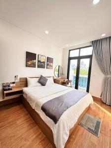 富国DTJ Hometel GRAND WORLD的一间卧室设有一张大床和一个大窗户
