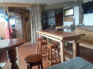 威廉斯港Refugio Jemmy Button的厨房配有木桌和一些凳子