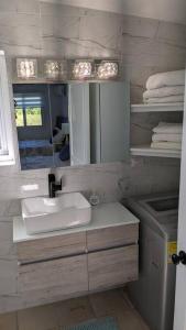 苏莎亚Breezy modern apartment steps from the beach的一间带水槽和镜子的浴室