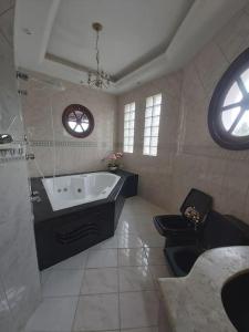 瓜鲁雅Castelinho do Felix Guarujá Pernambuco的带浴缸和卫生间的大型浴室