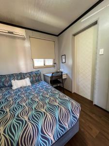 纽曼纽曼绿洲汽车旅馆的一间卧室配有一张床、一张书桌和一个窗户。