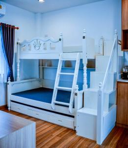 南府Nainan resotel ในน่าน รีโซเทล的客房内的白色双层床,带梯子