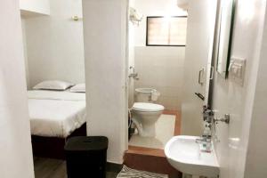 班加罗尔Clover Suites - Studios at Koramangala 4th block的浴室设有床、卫生间和水槽。