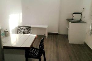 班加罗尔Clover Suites - Studios at Koramangala 4th block的客房设有木桌、桌子和厨房。