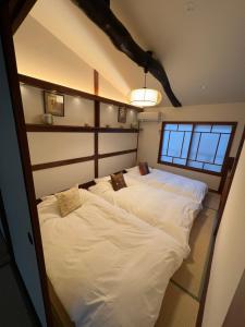 京都Imakumano Terrace - Dohachi An 道八庵的带窗户的客房内设有两张单人床。