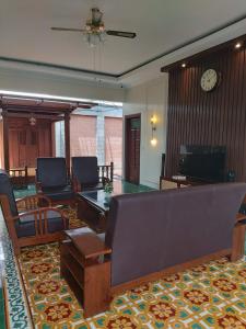 LaweanGuesthouse Syariah Griya Truntum的带沙发、椅子和时钟的客厅