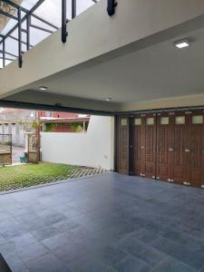 LaweanGuesthouse Syariah Griya Truntum的一个带木门的车库和庭院