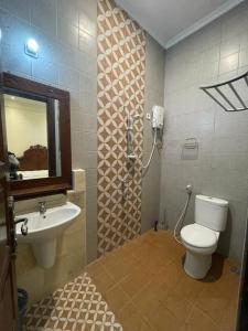 LaweanGuesthouse Syariah Griya Truntum的一间带卫生间、水槽和镜子的浴室