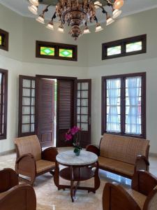 LaweanGuesthouse Syariah Griya Truntum的带沙发、桌子和窗户的客厅