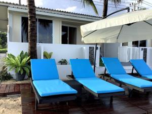 苏梅岛Nam Jai Beach Bungalow - Tropical的庭院里摆放着一组蓝色的椅子和一把遮阳伞