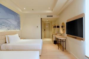 哥打京那巴鲁城市快捷克塔京那巴鲁的配有一张床和一台平面电视的酒店客房
