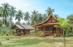 俊穆岛Kohjum Freedom Resort的一座棕榈树的小木房子