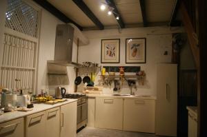 立咯海滩体验岛文化遗址度假屋的厨房配有白色橱柜和炉灶烤箱。