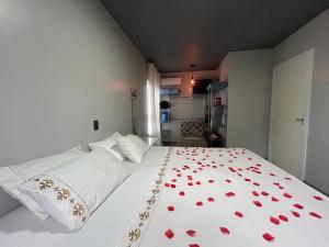 伊达贾伊Loft Praia Brava - Itajaí Camboriú piscina e playground的卧室配有一张红色的白色床